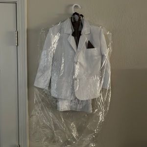 A boys tuxedo all white with burgundy tie and vest